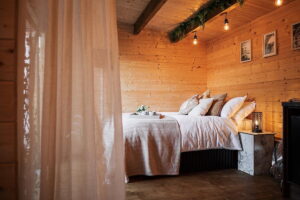 interior del dormitorio de la casa pequeña de madera con cortinas naturales y decoración