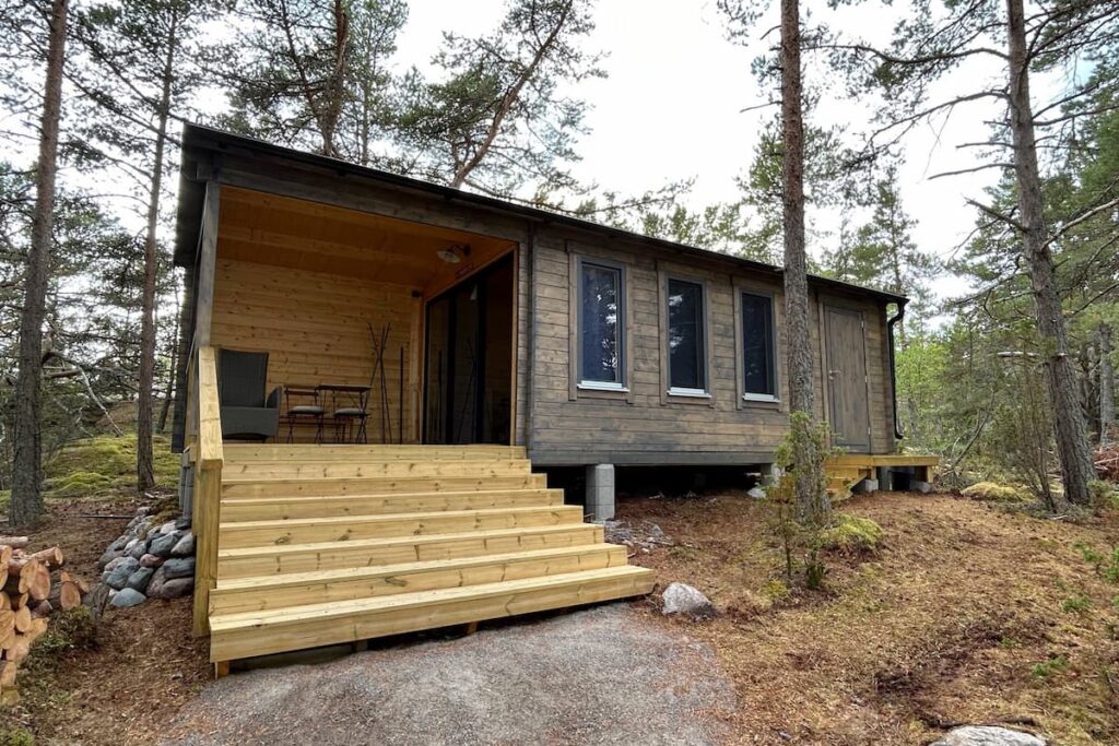 Cabaña de madera pintada en un bosque de pinos