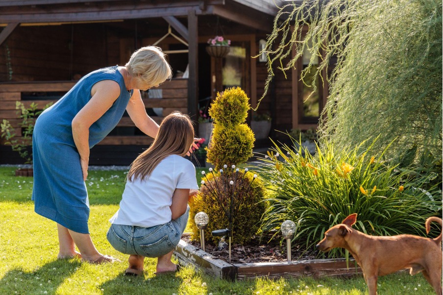 Dos mujeres y un perro en el jardín