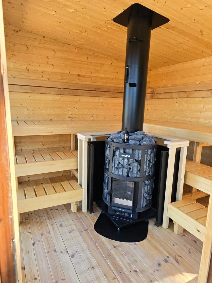 Sauna interior with wood-burning heater and sauna stones